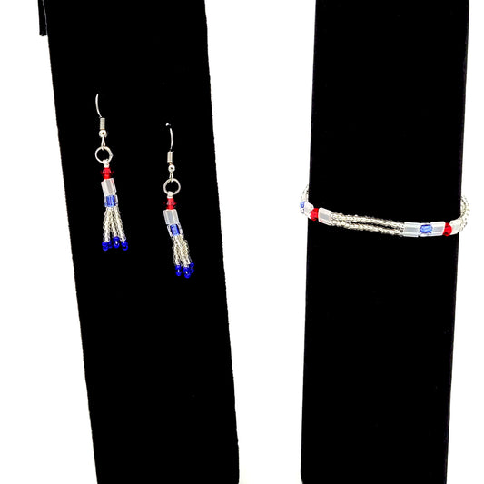 Bracelet and earrings made of red, white, and blue seed beads and slightly larger decorative beads on black velvet displays.