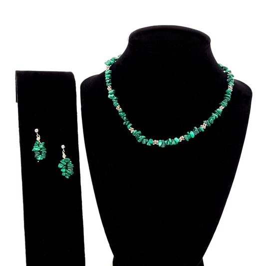 Necklace made of malachite chips, silver tone spacer beads and earring made of malachite chips on posts displayed on black velvet displays.