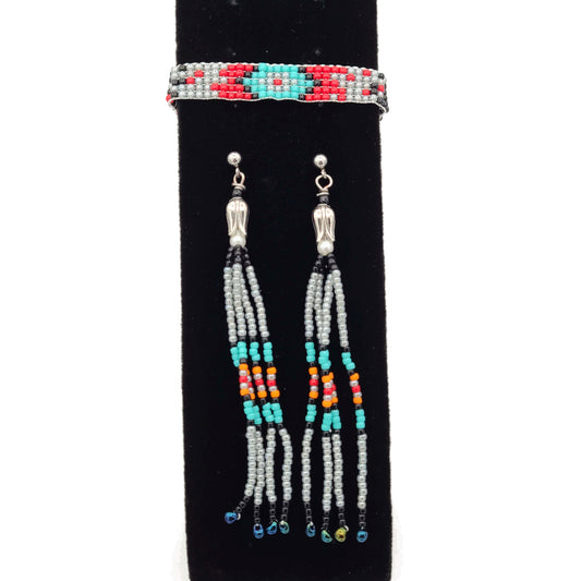 Fringe earrings of southwest colors and a matching bracelet on a black velvet display.