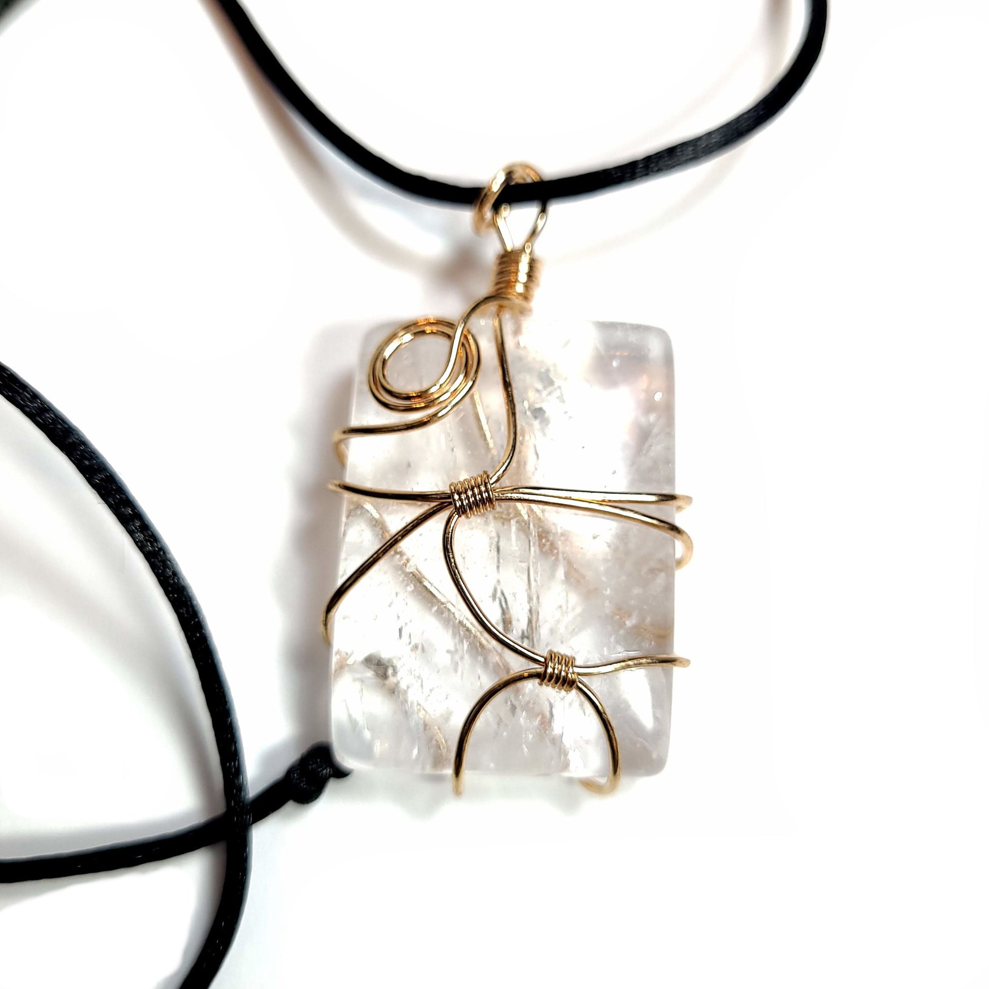 Rose gold colored wire wrapped Quartz Crystal with a black satin cord with an adjustable slip knot.