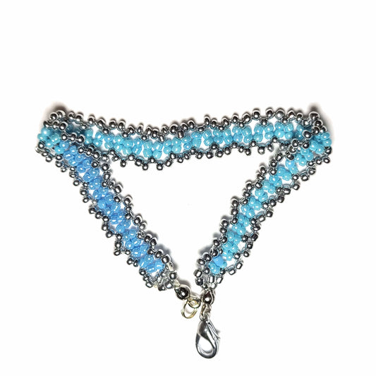 Bracelet made with powder blue and silver colored seed beads, with a silver colored lobster clasp.