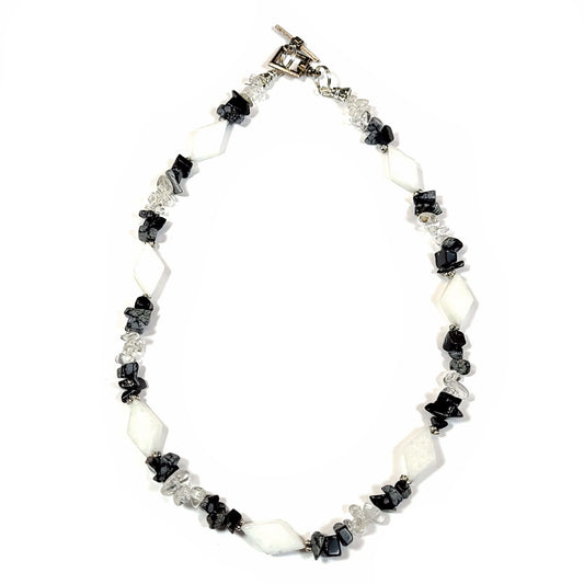 Necklace made of White quartz diamond beads, with crystal quartz chips and Snowflake Obsidian highlighted with silver tone spacer beads and bar and loop toggle clasp.