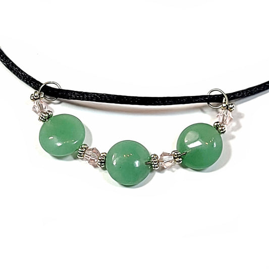 Close of of pendant on a necklace made with a satin cord and has a 3 aventurine disc beads pendant.