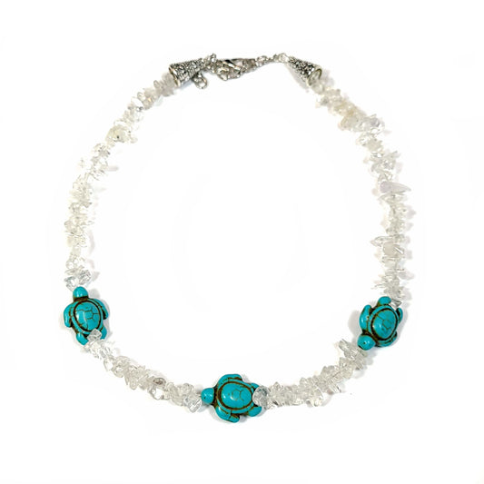 Necklace made of crystal quartz chips with aqua dyed howlite, and end caps with a silver tone extender chain and lobster clasp.