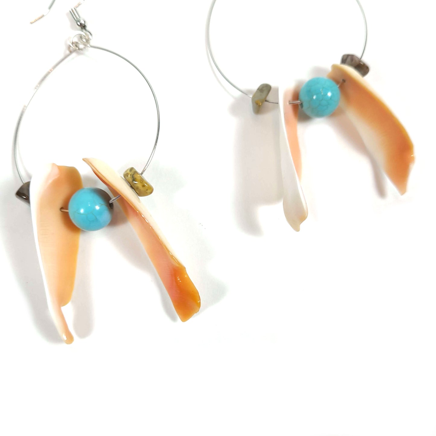 Two handcrafted silver colored wire hoop earrings with a jasper chip bead, a vintage shell, a turquoise bead, another vintage shell, and another jasper chip bead.